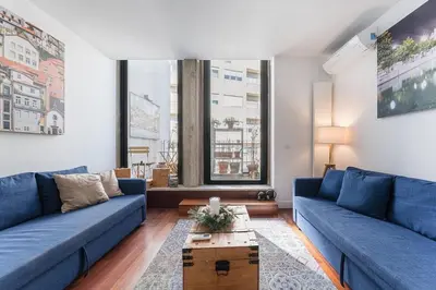 a living room with blue couches and a table at City-Center Apartments with Mezzanine and Terrace in Porto