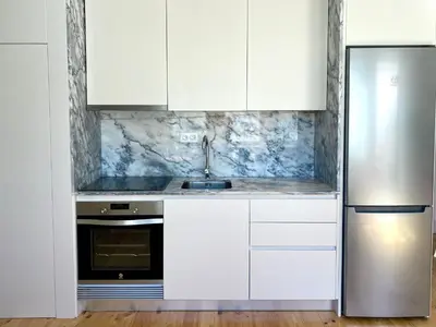 a kitchen with white cabinets and a stainless steel refrigerator at VIVA - Rooftop Terrace View Flat in Porto