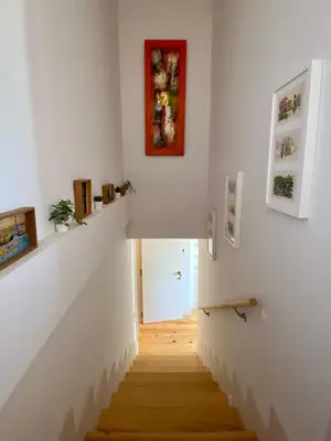 a staircase in a room with white walls and wooden floors at VIVA - Rooftop Terrace View Flat in Porto