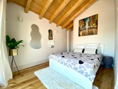 a bedroom with a bed in a room with wooden ceilings at VIVA - Rooftop Terrace View Flat in Porto