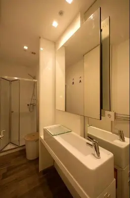 a bathroom with a sink and a mirror and a shower at Space Shuttle studios - Tiny House in Porto