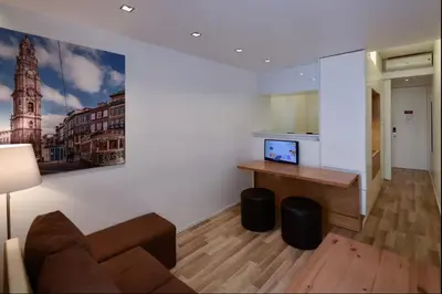 a living room with a couch and a desk and a painting at Space Shuttle studios - Tiny House in Porto
