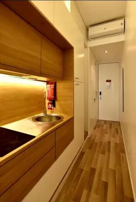a kitchen with a sink and a wooden floor at Space Shuttle studios - Tiny House in Porto