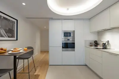 a kitchen with a table and two chairs and a microwave at Formosa City Studio in Porto