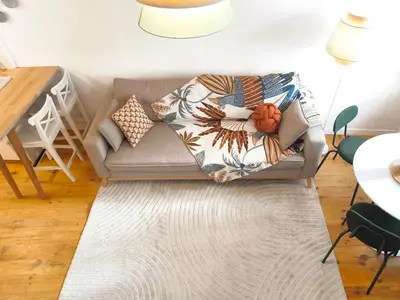 a living room with a couch with a blanket on it at Casa Moara - Downtown Duplex House in Porto