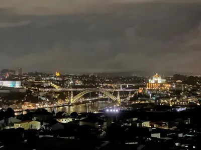 a view of a city at night with a bridge at New Douro 406 with parking in Vila Nova de Gaia