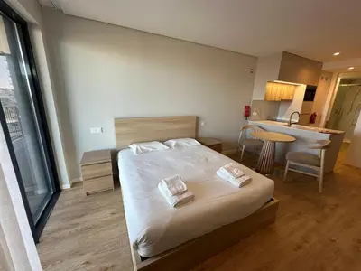 a bedroom with a bed and a table and a desk at New Douro 406 with parking in Vila Nova de Gaia