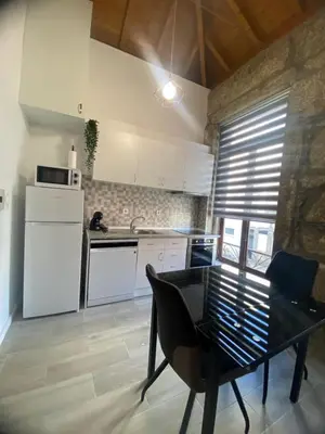 a kitchen with white appliances and a table in a room at Porto Saldanha - 2x T2 Duplex in Porto