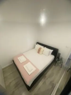 a bed with white sheets and pillows in a room at Porto Saldanha - 2x T2 Duplex in Porto