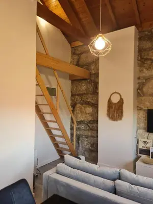 a living room with a couch and wooden ceilings at Porto Saldanha - 2x T2 Duplex in Porto