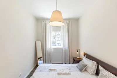 a bedroom with a large bed and a window at Now Trindade in Porto