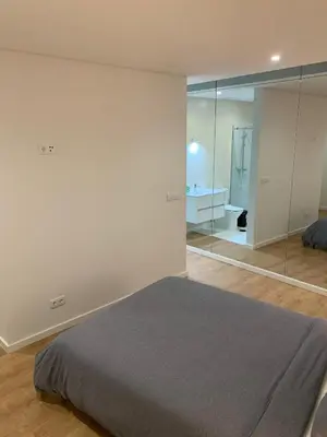 a bedroom with a bed and a large mirror at A melhor estadia do Porto in Porto