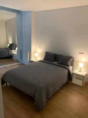 a bedroom with a large bed with two tables and two lamps at A melhor estadia do Porto in Porto
