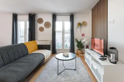 a living room with a couch and a tv at GuestReady - Homey experience in Porto in Porto