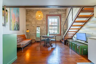 a living room with a staircase and a table at Essence Oporto Apartment Downtown in Porto