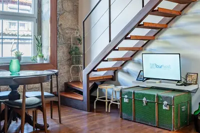 a staircase with a laptop computer on top of a suitcase at Essence Oporto Apartment Downtown in Porto