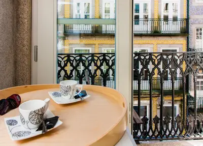 a table with two coffee cups on a balcony at Cardosas Charming Apartment with Balconies in Porto