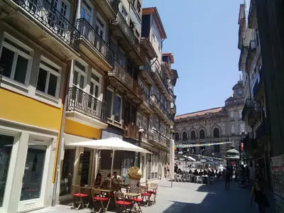a street with tables and umbrellas in a city at Cardosas Charming Apartment with Balconies in Porto