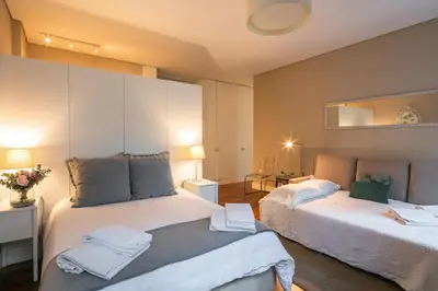 a bedroom with two beds and a mirror at Cardosas Charming Apartment with Balconies in Porto