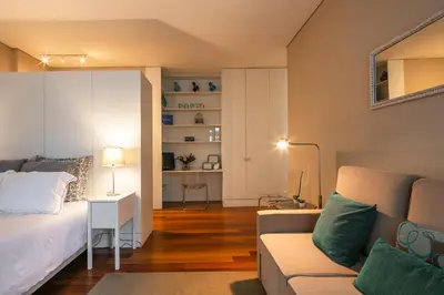 a living room with a bed and a couch at Cardosas Charming Apartment with Balconies in Porto