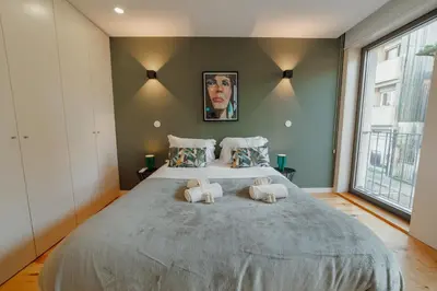 a bedroom with a large bed with two towels at Gaia Premium Apartments by Vacationy in Porto