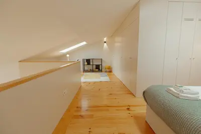 an attic bedroom with a bed and a hallway at Gaia Premium Apartments by Vacationy in Porto