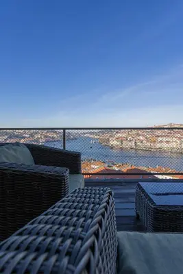 a balcony with wicker furniture and a view of the ocean at Local 167 - Oporto View House in Vila Nova de Gaia