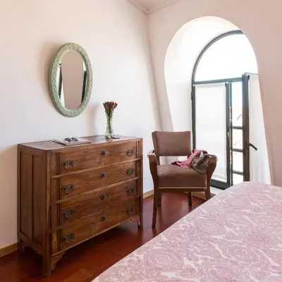 a bedroom with a dresser and a chair and a mirror at Seagull Rooftop Downtown - Light and Views in Porto