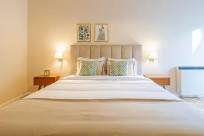 a bedroom with a large white bed with two lamps at 3BR Joyous Wonder by LovelyStay in Porto