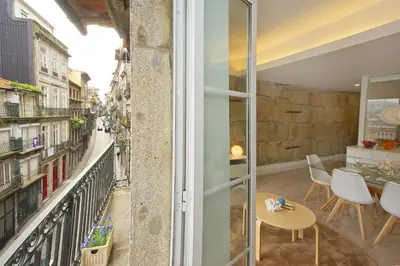 a room with a balcony with a table and chairs at Largo São Domingos by Innapartments in Porto