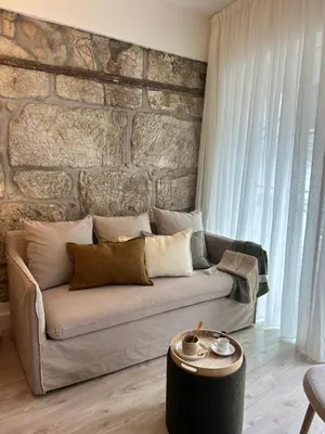 a living room with a couch and a brick wall at Largo São Domingos by Innapartments in Porto