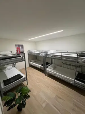 a room with three bunk beds and a wooden floor at Varandas do Porto Coliving in Porto