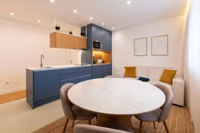 a kitchen and living room with a white table and chairs at DoisPontoZero NAVY in Porto