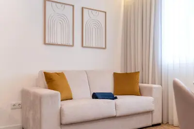a white couch with two pillows in a living room at DoisPontoZero NAVY in Porto