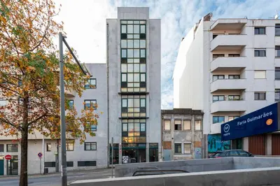a tall white building in a city at DoisPontoZero NAVY in Porto