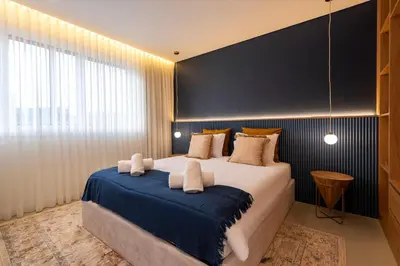 a bedroom with a large bed with a blue blanket at DoisPontoZero NAVY in Porto