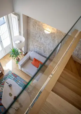 a living room with a glass staircase with a couch at Portobliss Apartment in Porto