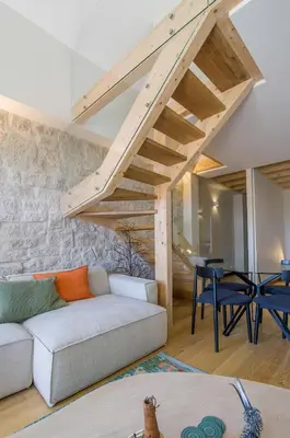 a living room with a white couch and wooden stairs at Portobliss Apartment in Porto