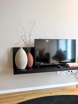 a black shelf with two vases and a tv at Oporto Serviced Apartments - Miragaia II in Porto