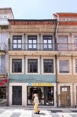 a woman walking in front of a building at Once Upon In Porto Apartments II in Porto