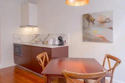 a kitchen with a wooden table with chairs and a sink at Once Upon in Porto Apartments I in Porto