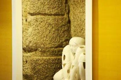 a white statue sitting next to a stone wall at In Porto Gallery Guesthouse in Porto