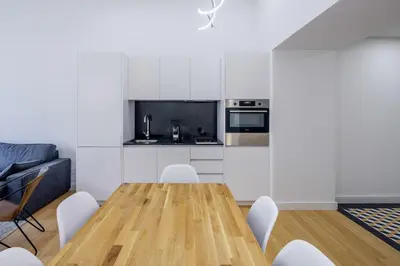 a kitchen and dining room with a wooden table and chairs at Aliados Living Apartment in Porto