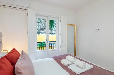 a kitchen with white cabinets and a wooden floor at Almada Prime Apartment I in Porto