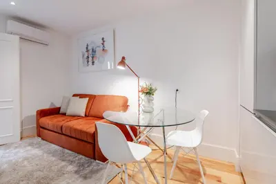 a living room with a couch and a tv on a wall at Almada Prime Apartment I in Porto