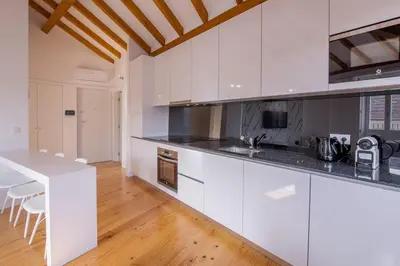 a kitchen with white cabinets and a white counter top at Almada Prime Apartment II in Porto