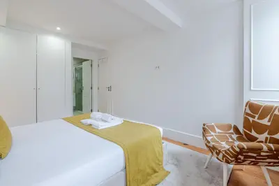 a white bedroom with a large bed and two windows at Almada Prime III in Porto