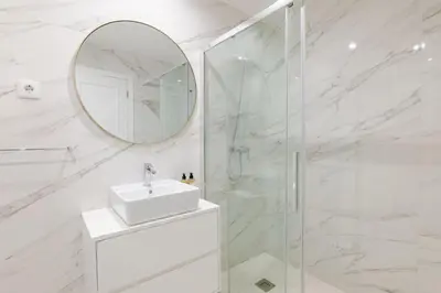 a kitchen with a glass table and white chairs at Almada Prime III in Porto