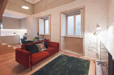 a living room with a red couch and a kitchen at Andrade Rooftop Duplex in Porto