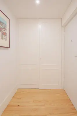 an empty room with white walls and wood floors at Canto Flores in Porto